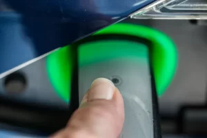 Doigt appuyant sur le bouton de déverrouillage d'un chargeur de voiture électrique.